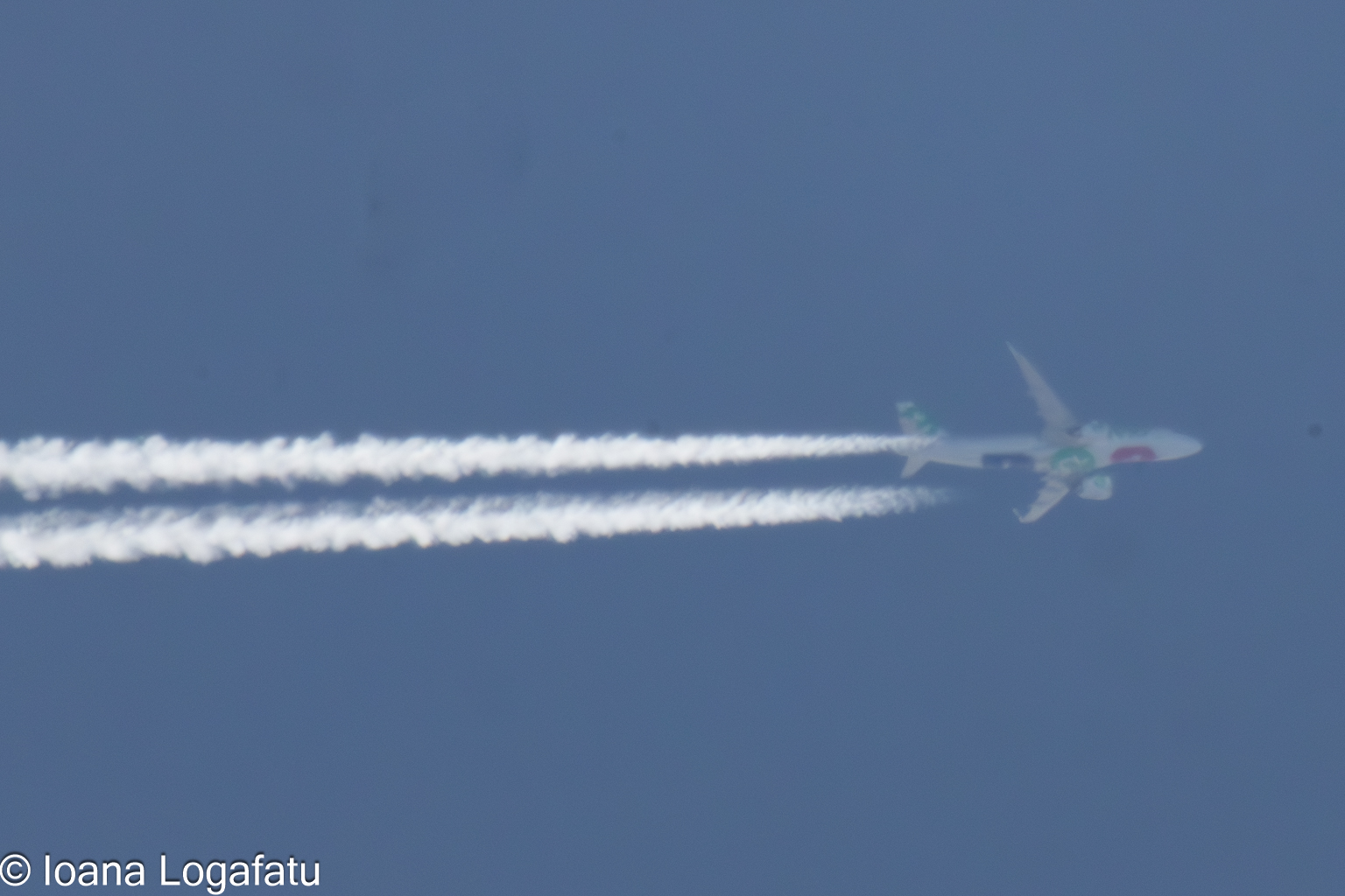 Plane gliding through a bright blue sky